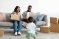 Happy family using laptop playing with kid after relocation Royalty Free Stock Photo