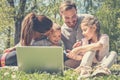 Happy family using laptop, sitting on the green grass. Family en Royalty Free Stock Photo