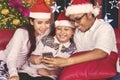 Happy family using a smartphone at Christmas time Royalty Free Stock Photo