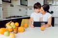 Happy family using a tablet pc in kitchen Royalty Free Stock Photo