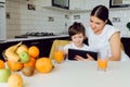 Happy family using a tablet pc in kitchen Royalty Free Stock Photo