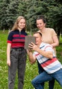 Happy family using tablet PC outdoors Royalty Free Stock Photo
