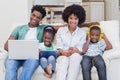 Happy family using technologies on the couch Royalty Free Stock Photo