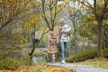 Happy family walking in autumnal park. Stylish young Caucasian Mother with kids. Autumn fashion. Fall season Royalty Free Stock Photo