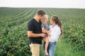 Happy family walking in the park. Mom, dad and daughter walk outdoors, parents holding the baby girl`s hands. Childhood, Royalty Free Stock Photo