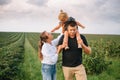 Happy family walking in the park. Mom, dad and daughter walk outdoors, parents holding the baby girl`s hands. Childhood, Royalty Free Stock Photo