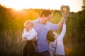 Happy family walking in the park on a sunny day. Father with adorable toddler boy and cute kid boy having fun on a summer meadow Royalty Free Stock Photo