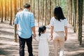 Happy family walking through the sunny forest