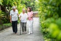 Happy family walking together in the garden. Old elderly using a walking stick to help walk balance. Concept of Love and care of