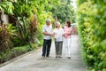Happy family walking together in the garden. Old elderly using a walking stick to help walk balance. Concept of Love and care of