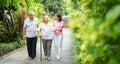 Happy family walking together in the garden. Old elderly using a walking stick to help walk balance. Concept of  Love and care of Royalty Free Stock Photo