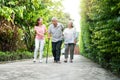 Happy family walking together in the garden. Old elderly using a walking stick to help walk balance. Concept of Love and care of Royalty Free Stock Photo