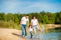 Happy family walks along the riverbank