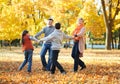 Happy family walks in autumn city park. Children and parents posing, smiling, playing and having fun. Bright yellow trees. Royalty Free Stock Photo