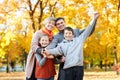 Happy family walks in autumn city park. Children and parents posing, smiling, playing and having fun. Bright yellow trees. Royalty Free Stock Photo