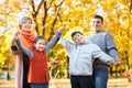 Happy family walks in autumn city park. Children and parents posing, smiling, playing and having fun. Bright yellow trees. Royalty Free Stock Photo