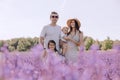 A happy family walks in a blooming lavender field