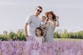 A happy family walks in a blooming purple lavender field