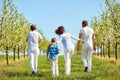 Happy family walks in the garden in spring, summer. Back view. Royalty Free Stock Photo