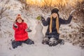 Happy family in warm clothing. Smiling mother and son making a snowman outdoor. The concept of winter activities Royalty Free Stock Photo