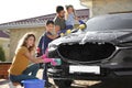 Happy family washing car at backyard