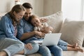 Happy family watching funny movie on computer with small daughter. Royalty Free Stock Photo