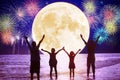 Family watching the moon and fireworks on the beach Royalty Free Stock Photo