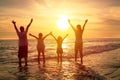 Happy family watching the sunset on the beach