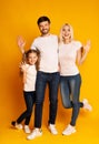 Happy Family Waving Hands Over Yellow Background