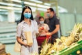 Family wearing face protective medical masks for protection from virus disease with shopping cart buying food at supermarket Royalty Free Stock Photo