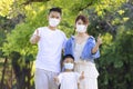 Happy family wearing medical masks to protection and showing thumbs up Royalty Free Stock Photo