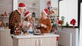 Happy family wearing santa hat celebrating christmas day holiday eating baked chocolate cookies Royalty Free Stock Photo