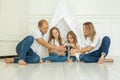 Happy family in white t-shirts cuddling little pet dog. Mother, father, two little daughters with puppy dog on floor Royalty Free Stock Photo