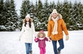 Happy family in winter clothes walking outdoors Royalty Free Stock Photo