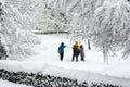 Happy family in winter clothes walking in a snow covered park city, healthy lifestyle. Royalty Free Stock Photo