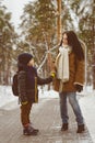 Happy family in winter clothing. Little boy holding the hand of his mother Royalty Free Stock Photo