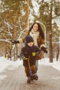 Happy family in winter clothing. Smiling son runs away from his mother outdoor Royalty Free Stock Photo