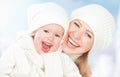 Happy family on a winter walk. Mother and baby daughter in the white hats Royalty Free Stock Photo