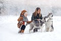 Happy family in the winter wood plays huskies Royalty Free Stock Photo