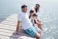 Happy family on wooden bridge against the backdrop of the sea or lake Royalty Free Stock Photo
