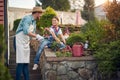 Happy family working outdoors. Young father and girl planting flowers in the flower garden by the house on a sunny summer day, Royalty Free Stock Photo