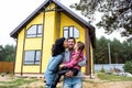 Happy family in the yard of an unfinished house - purchase of a cottage, mortgage, loan, relocation, construction Royalty Free Stock Photo