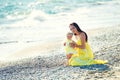 Happy family in a yellow dress. Mother and child are walking on the beach Royalty Free Stock Photo