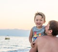 Happy family. Young beautiful father and his smiling son baby boy having fun on the beach of the sea, ocean. Positive human emotio Royalty Free Stock Photo