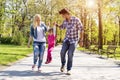 Happy family, young caucasian parents hiking with their daughter in a park Royalty Free Stock Photo