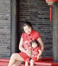 happy family young Chinese mother has fun with baby in China traditional cheongsam