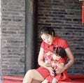 happy family young Chinese mother has fun with baby in China traditional cheongsam