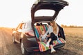 Happy family, a young mother with a child sitting in the trunk of a car, traveling Royalty Free Stock Photo