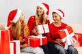 Happy family  a young mother with children  wearing santa claus hats  greets the New Year and gives each other Christmas gifts Royalty Free Stock Photo