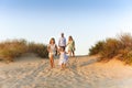 Happy family young parents two kids walking on sandy beach on sunny day during summer vacation Royalty Free Stock Photo